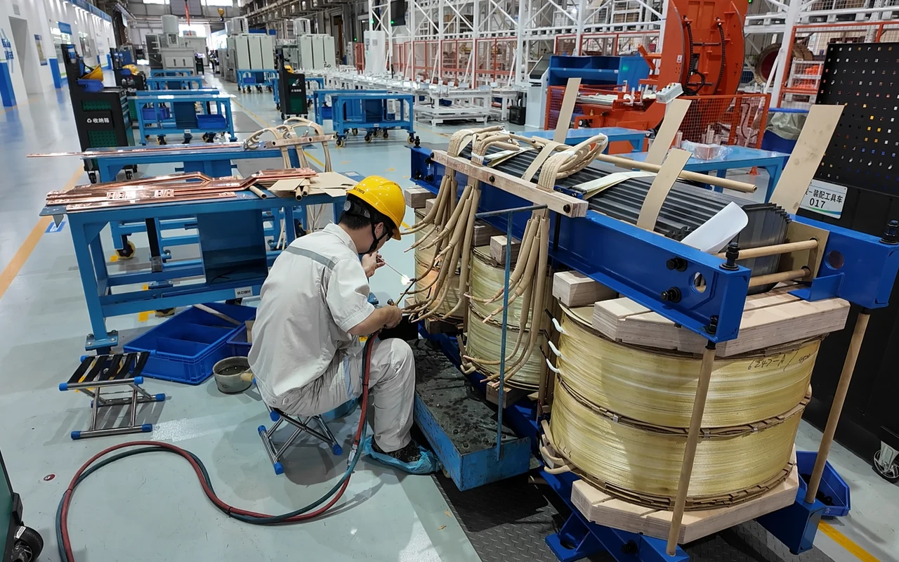 Technician connecting insulated transformer leads during active-part assembly